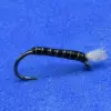 Black fly fishing lure with white thread wraps and a wispy tail on a blue background.