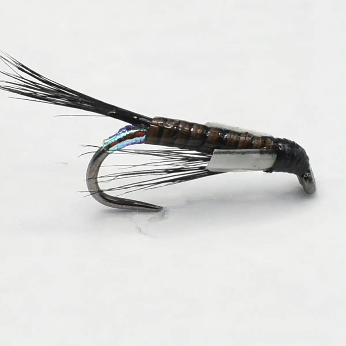 Metallic fishing fly lure with brown ribbed body and black feathered tail, mounted on a curved hook.
