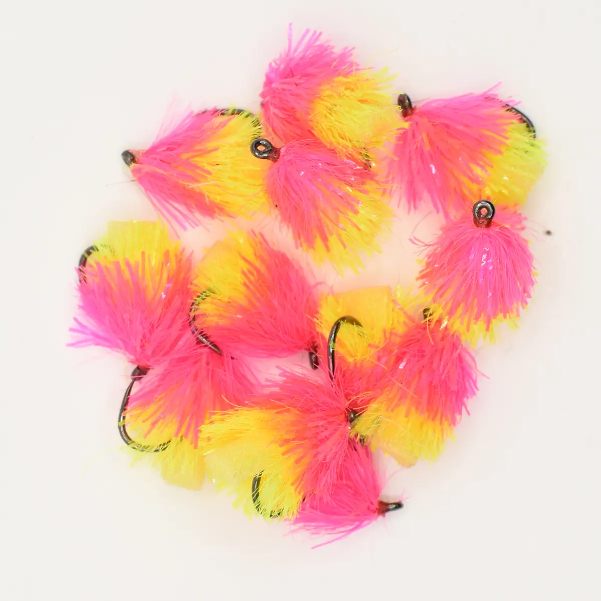 Cluster of bright pink and yellow fluffy fishing lures with small hooks on a white background, neon pom-pom style