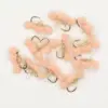 Cluster of pink fluffy fishing lures with gold tinsel and hooks on a white background.