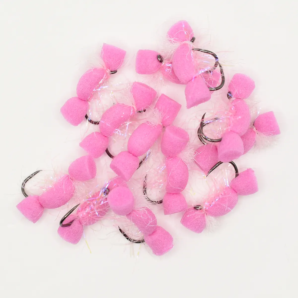 Pile of pink fuzzy pom-pom fishing lures with metal hooks