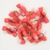 Pile of pink foam fishing lures with hooks and tinsel decoration on a white background.”,