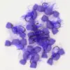 Several purple fuzzy pom-pom fishing lures with hooks on a white surface.