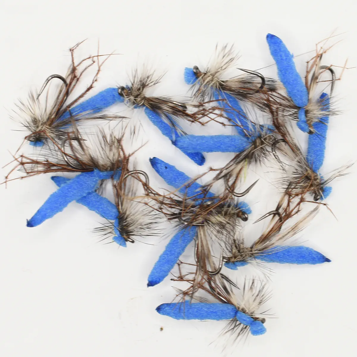Collection of blue-foam fishing flies with brown hackle tied on hooks for fly fishing.