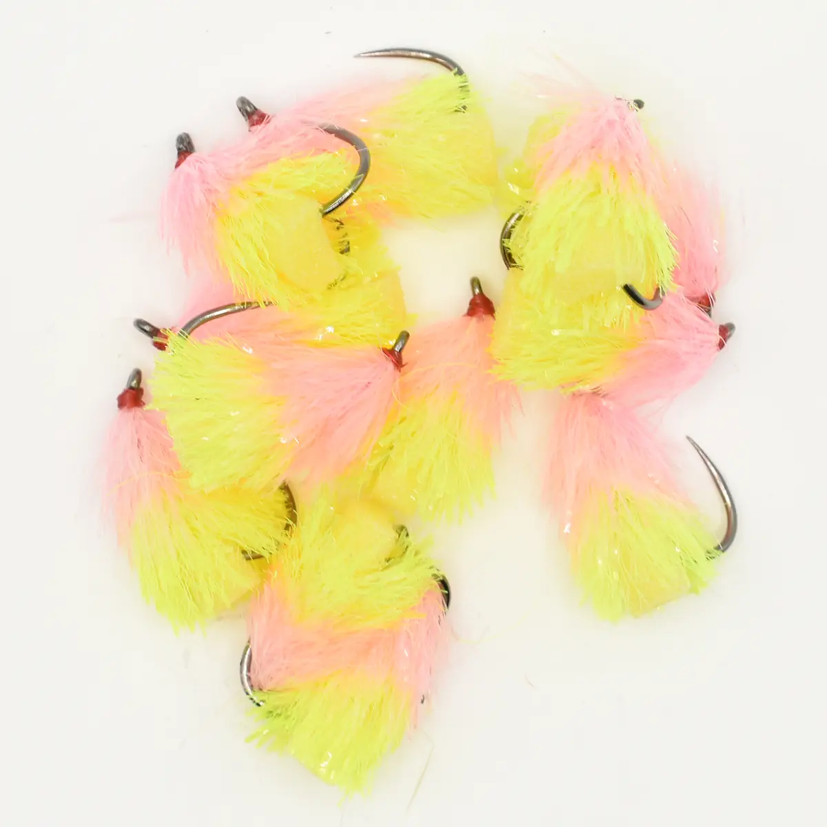 Assorted bright pink and yellow fluffy fishing flies with hooks for fly fishing