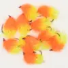 Bright orange and yellow fuzzy fishing lures with hooks arranged together, used as bait for fishing.