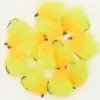 Collection of neon yellow and orange fluffy fishing flies with red heads and curved hooks.
