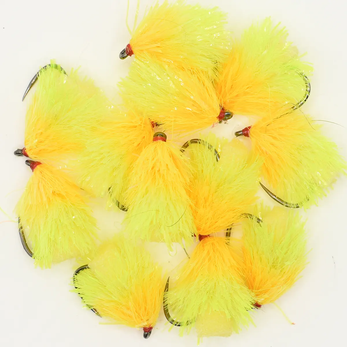 Collection of neon yellow and orange fluffy fishing flies with red heads and curved hooks.