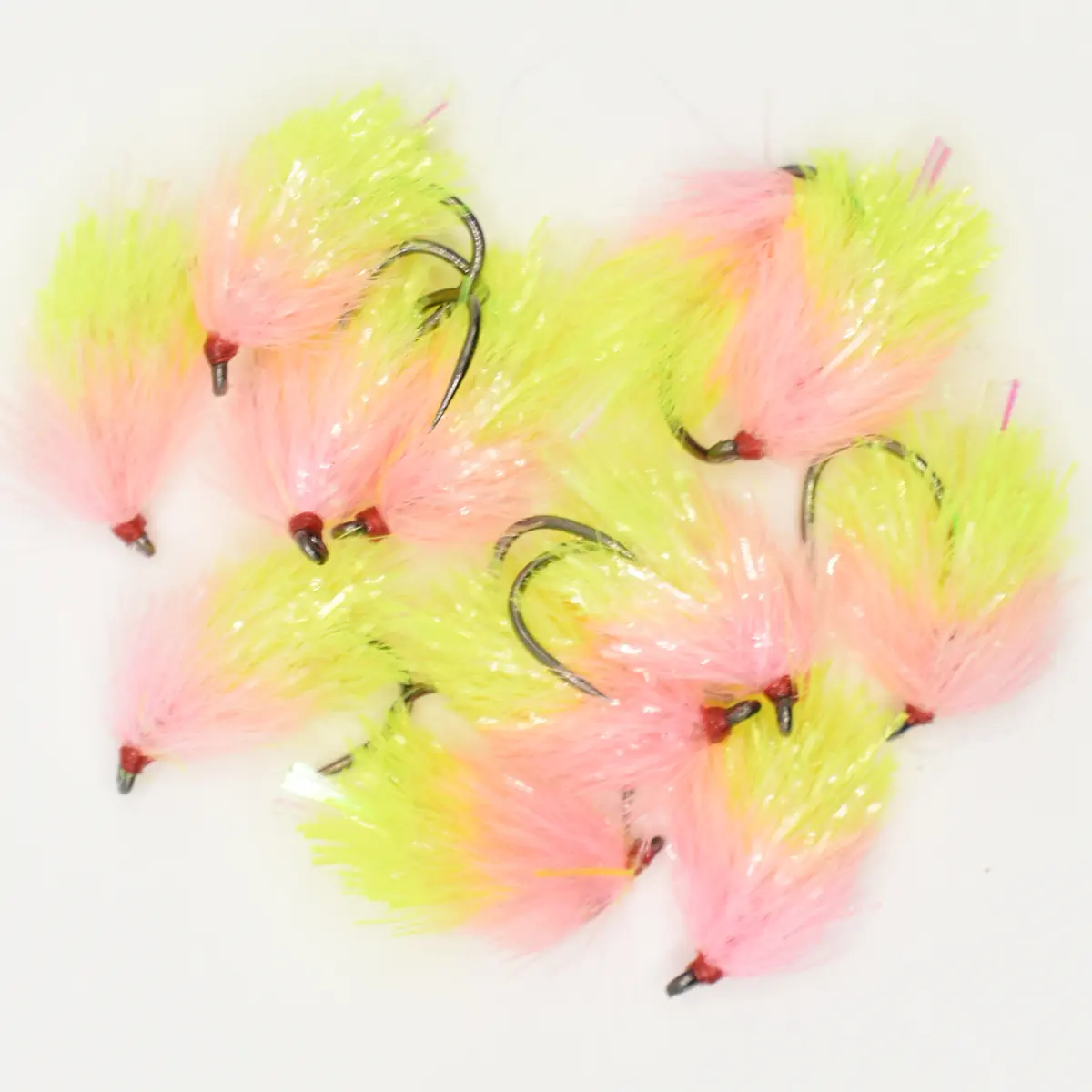 Assorted neon pink and yellow marabou fishing flies with hooks on a white background.