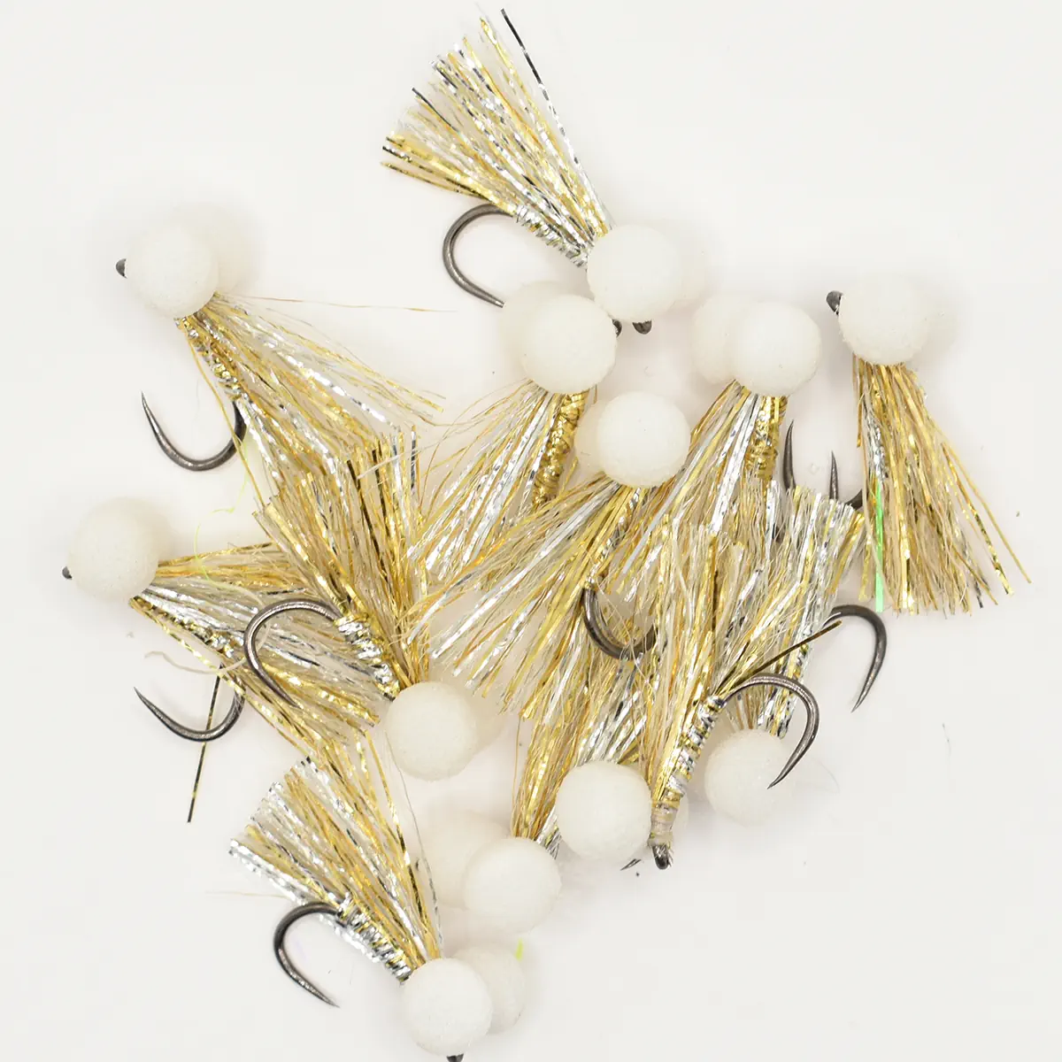 Collection of jig fishing lures with white foam ball heads and gold/silver tinsel bodies