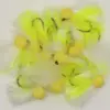 Assorted bright yellow fishing flies with fluffy white feathers and curved hooks