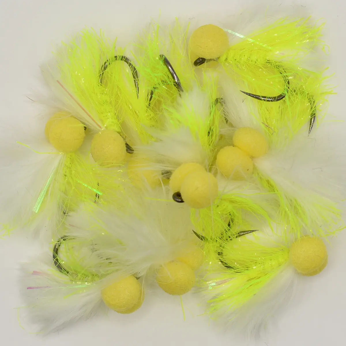Assorted bright yellow fishing flies with fluffy white feathers and curved hooks