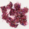 Close-up of pink, purple, and blue metallic tinsel garland strands arranged in a curly decorative shape on a white background (festive décor accessory).