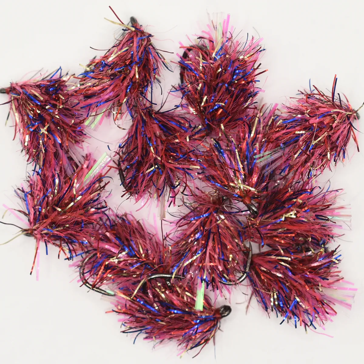Close-up of pink, purple, and blue metallic tinsel garland strands arranged in a curly decorative shape on a white background (festive décor accessory).