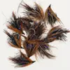 Assortment of brown and black fishing flies with purple tinsel and feather fibers on a white background