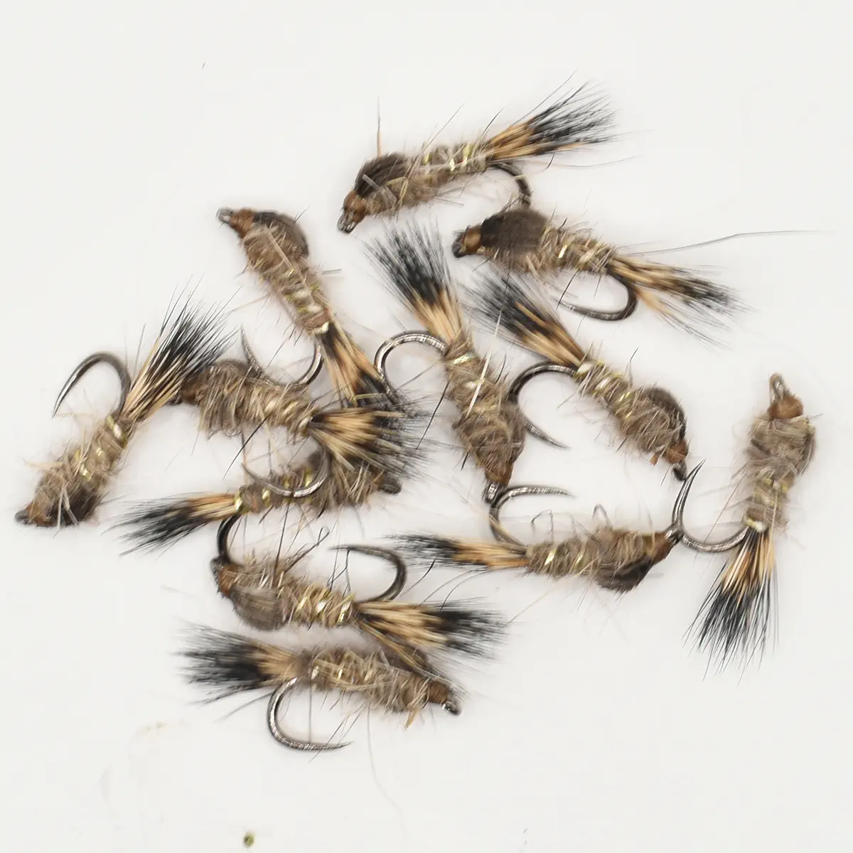 Assorted fishing flies tied with brown and tan feathers arranged on hooks.
