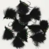 Collection of black feathered fishing lures with green bead accents and hooks for fly fishing