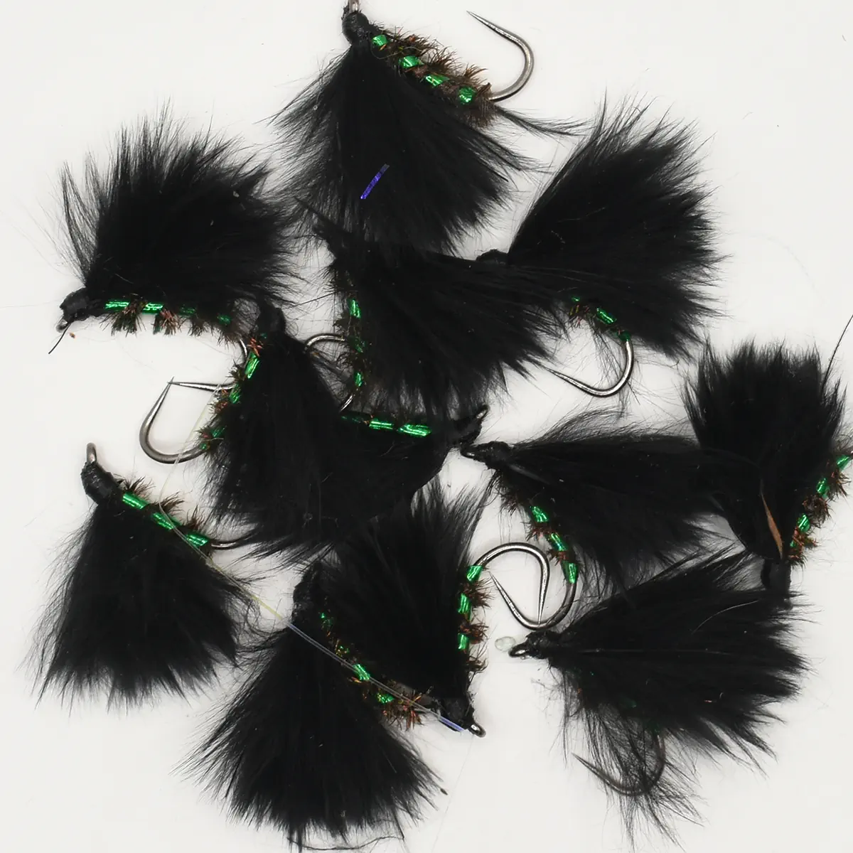 Collection of black feathered fishing lures with green bead accents and hooks for fly fishing