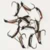 Collection of metallic fishing flies with feather tails arranged on a white background, ready for tying or use in fly fishing