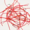 Pile of bright red fishing rigs with small curved hooks tangled together on a white surface, showing red tubing and wrapped sections