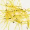 Pile of yellow soft-plastic fishing lures with hooks and beads scattered on a white surface, tangled together.