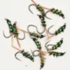 Assortment of green-wrapped fishing flies with metallic hooks on a white background, used for fly fishing.