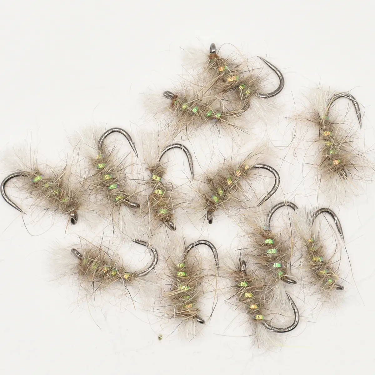 Assortment of beige, fur-covered fishing flies with green bead accents on a white background (fishing lures)