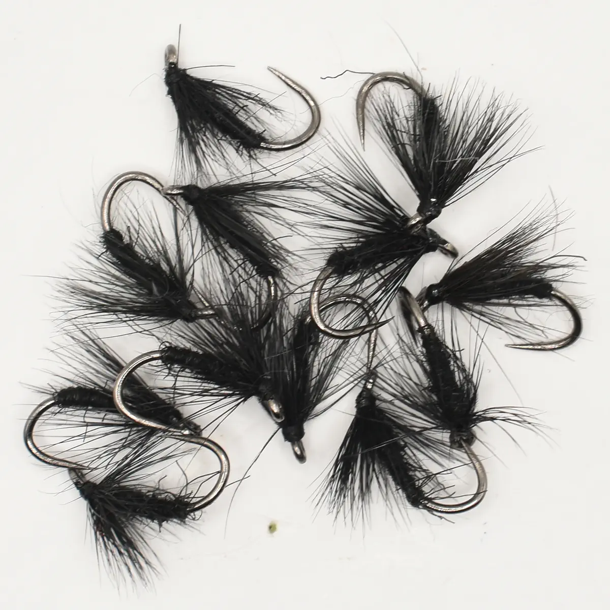 Assorted black feathered fishing flies with curved hooks for fly fishing