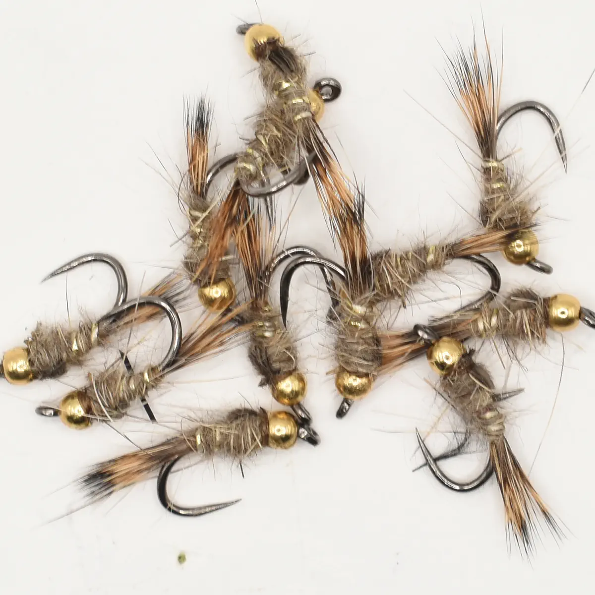 Assorted hand-tied fishing flies with bead heads on a white background for fly fishing.