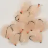 Cluster of peach-colored fluffy fishing flies with orange bead heads and black hooks