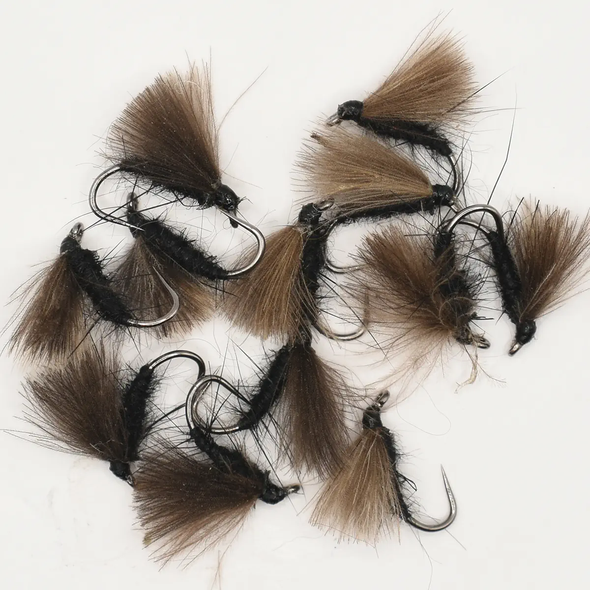 Assorted brown and black woolly bugger fishing flies with metal hooks, used for fly fishing