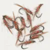 Assorted red-wrapped fishing flies with brown hackle scattered on a white background.