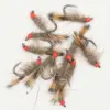 Collection of fur-covered fishing flies with orange thread heads and sharp metal hooks laid out on a white background