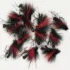 Assortment of black and red fuzzy fishing flies with hooks laid on a white background