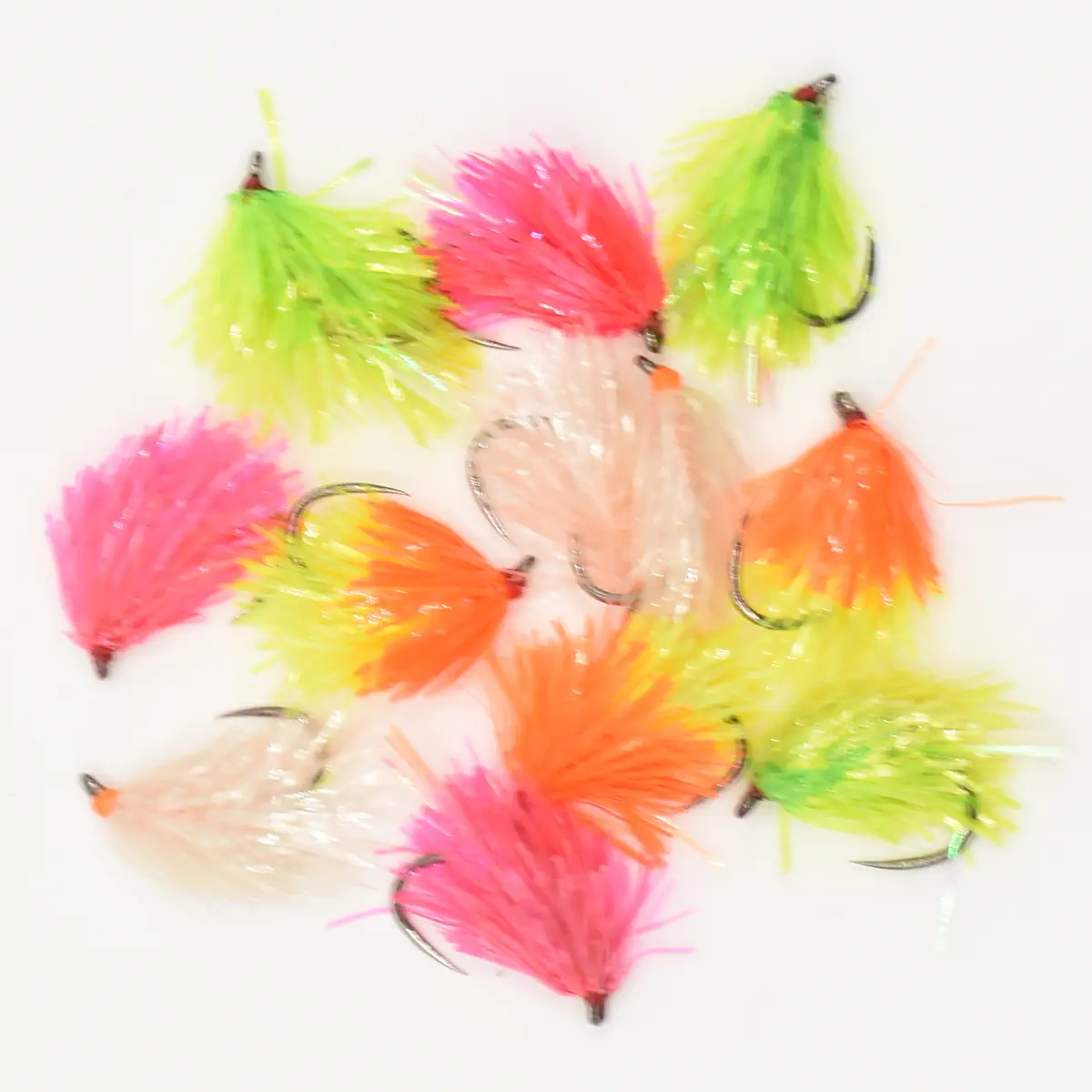 Assortment of bright, fluffy fishing flies in pink, orange, and lime green on a white background.