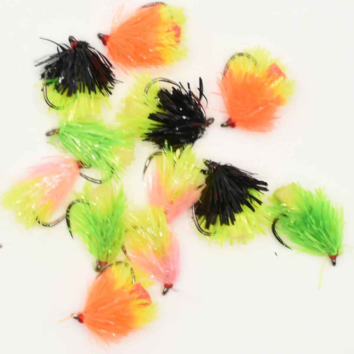Assorted colorful marabou fishing jigs scattered on a white background, featuring neon green, pink, orange, and black feathers with hooks visible.