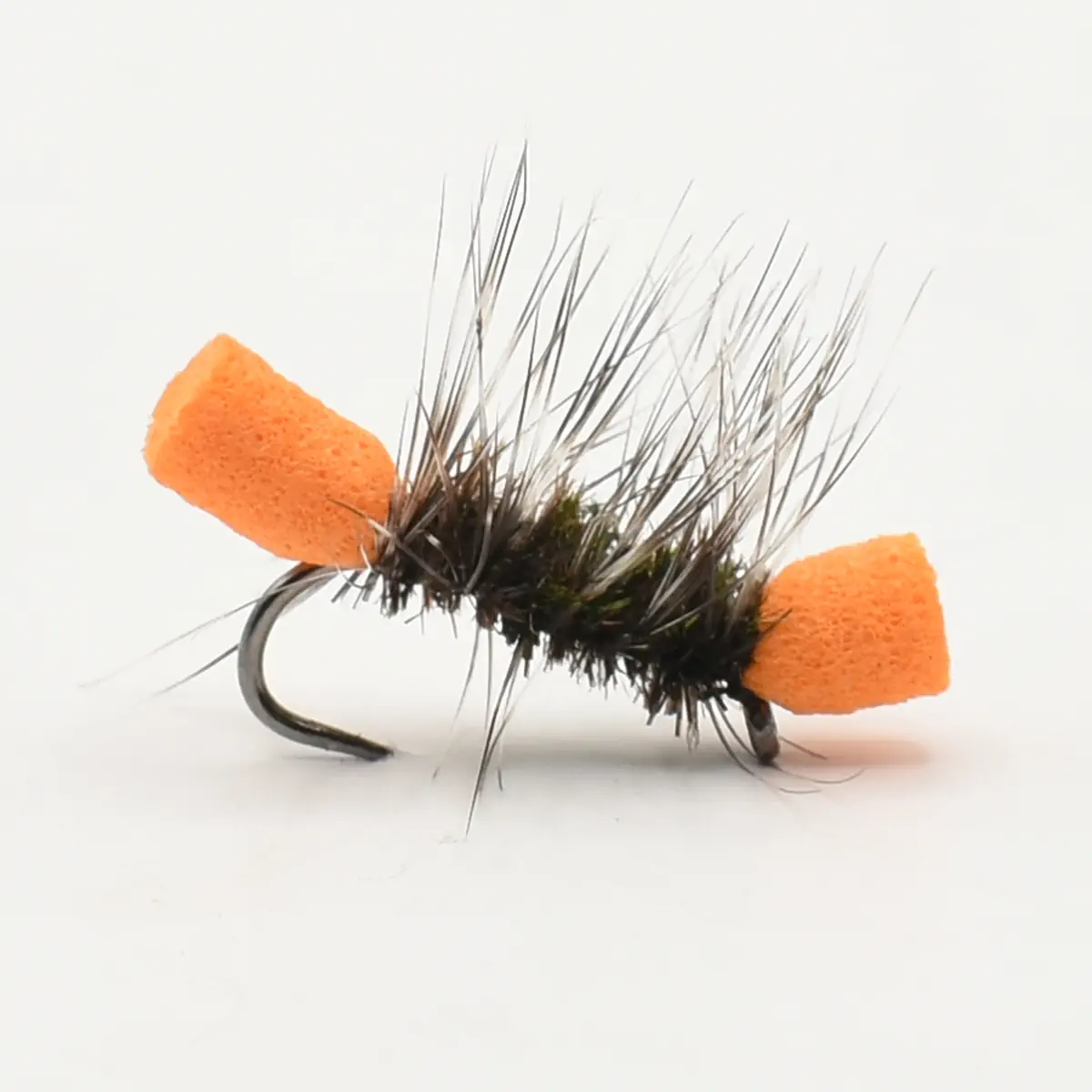 Close-up of a black, fuzzy fishing fly with orange foam posts on a curved hook, used for trout fishing.