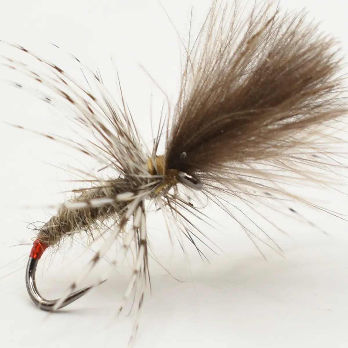 Close-up of a fishing fly lure tied to a metal hook with brown fur and feather fibers used for trout fishing